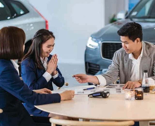 asian women at a car showroom purchasing a new car