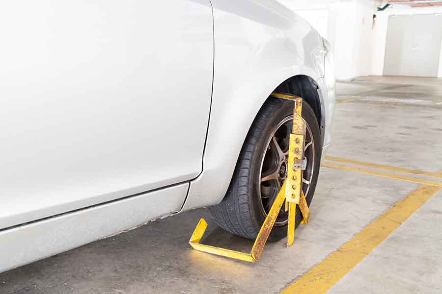 Car wheel clamped for illegal parking violation at car park