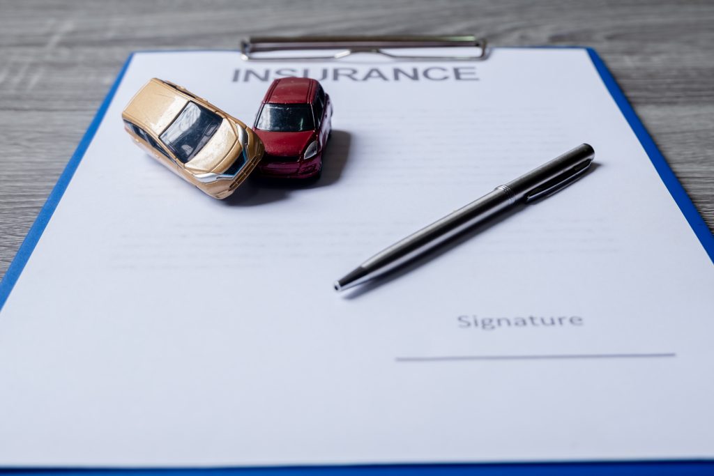 car and pen on insurance documents