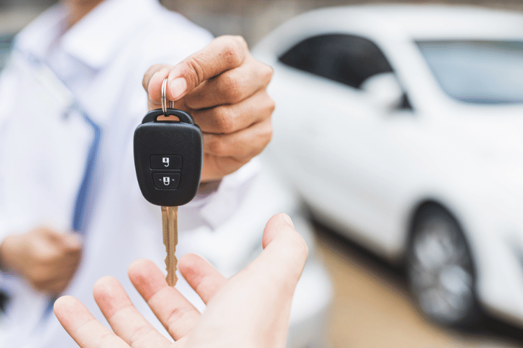 Close-up of a man giving a car key for a buyer